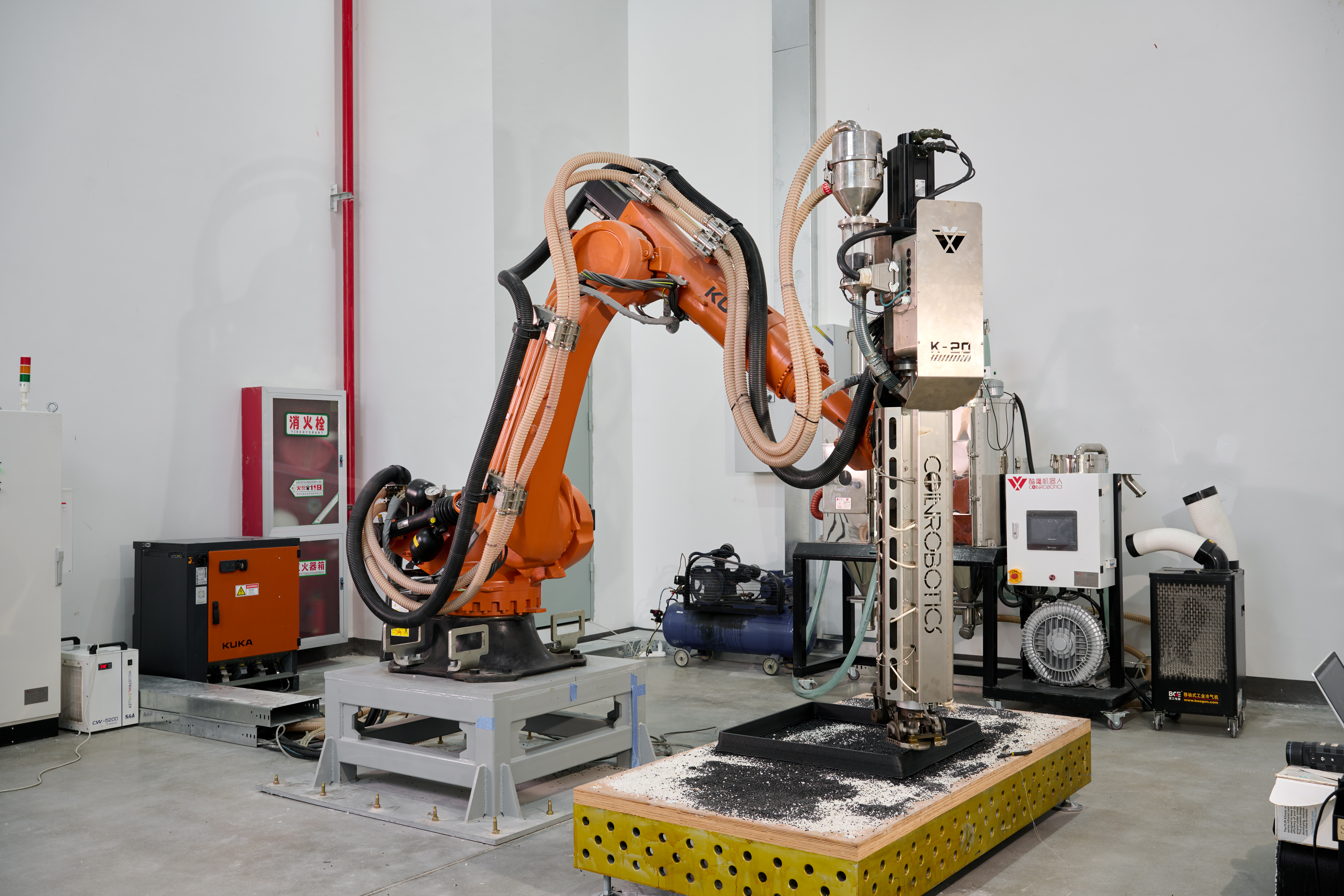 Large-format additive manufacturing (LFAM) setup with a robotic arm and granule extrusion system.